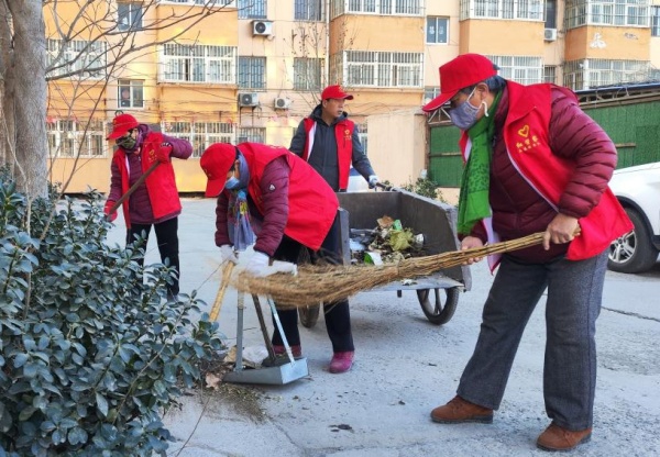 “红管家”宋红彬带领小区居民共同进行保洁作业。郑楠摄