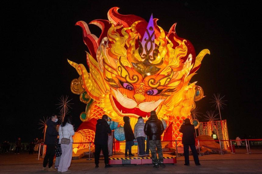 河北省唐山市南湖旅游景区，游客与“年兽”互动。赵杰摄