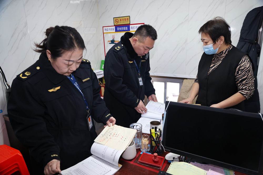 执法人员对年夜饭承接餐饮单位的食品采购、安全管理制度进行严格检查。杨洋摄