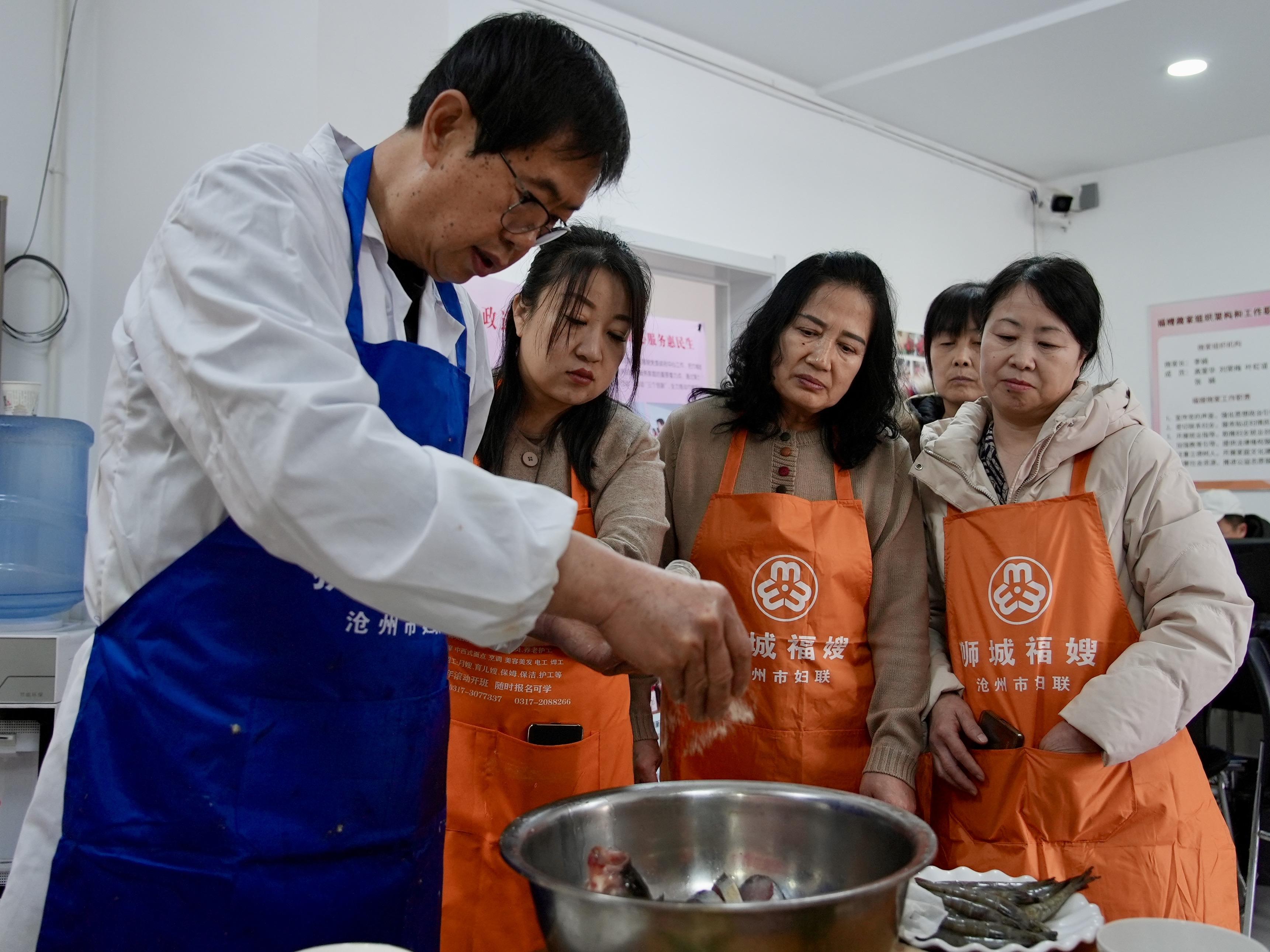 居民认真学习烹饪技巧。马鑫宇摄