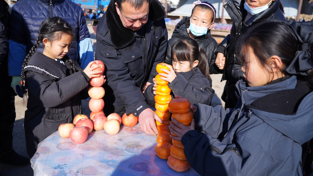 迁安市的群众在集市上参加摞苹果、垒柿子比赛。鲁学研摄