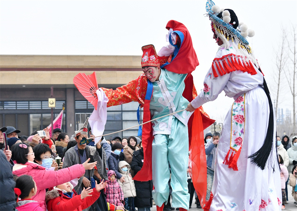 2月1日，在位于河北省沧州市的中国大运河非物质文化遗产展示馆广场，高跷演员与游客互动。苑立伟摄