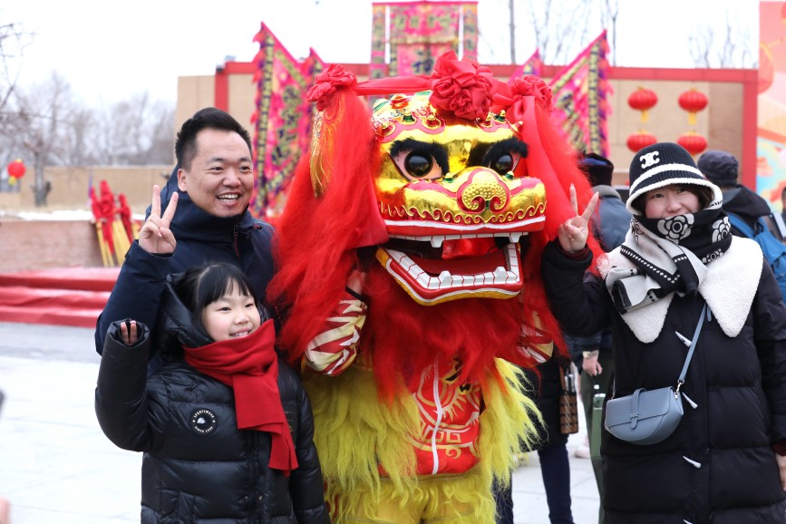 2月1日，游客在与非遗舞狮互动。田博摄