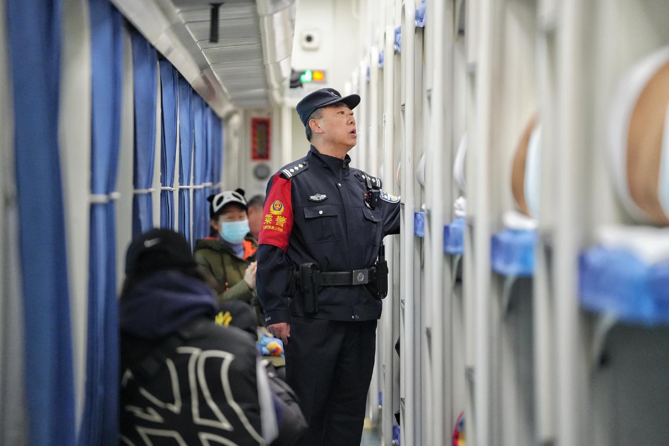 K7708次列車乘警錢振峰在車廂加大巡查頻次，提醒旅客注意乘車安全。賈義涵攝