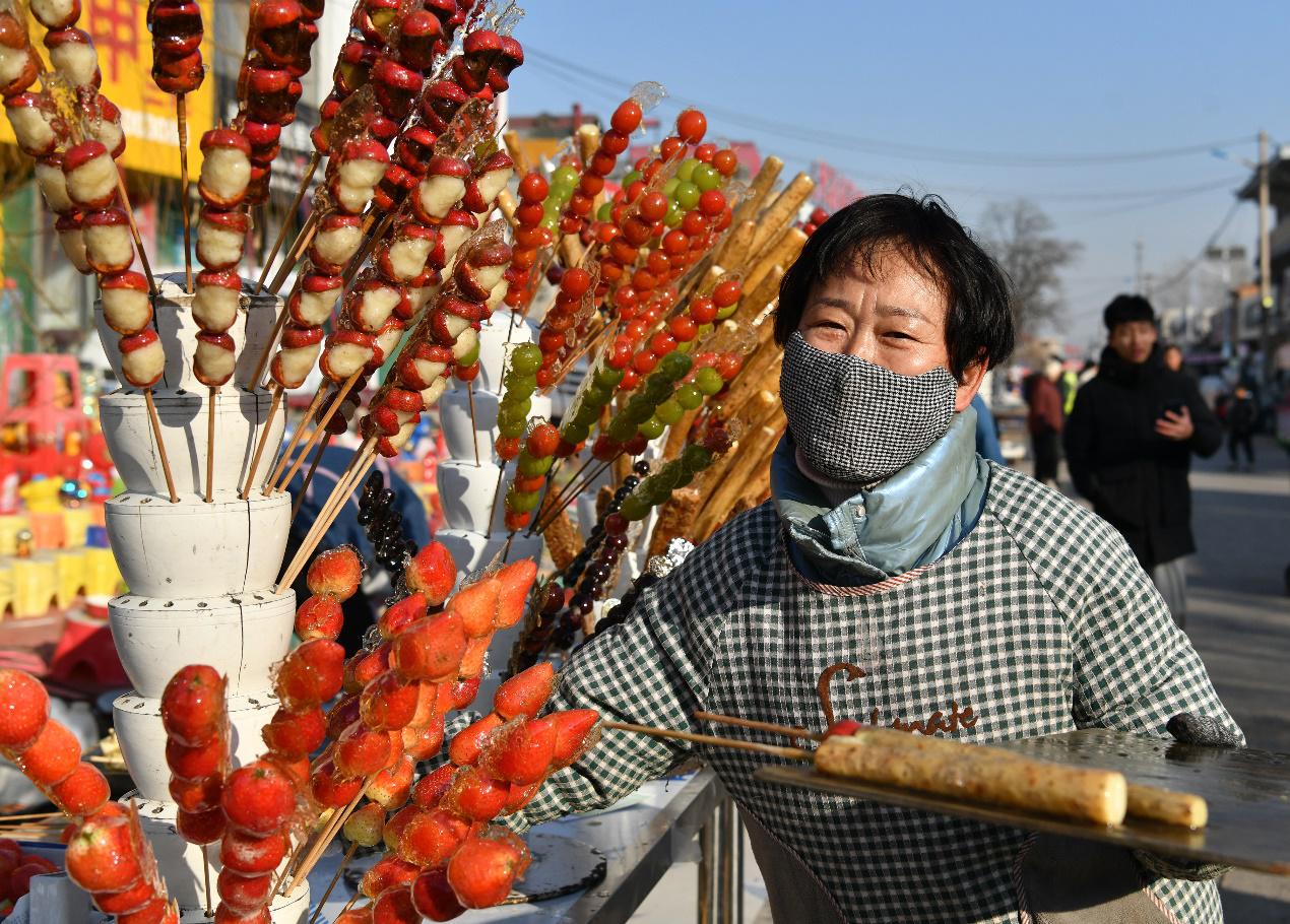 2月9日，商贩在后李花村“糖墩儿节”上摆放糖墩儿。苑立伟摄