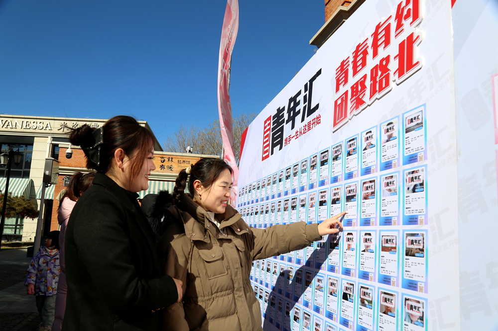 活动现场，居民在相亲交友摊位前浏览信息。马雅雄摄