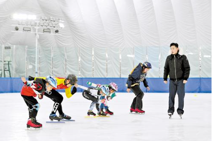 2月11日，石家庄弘象短道速滑俱樂部教練李昊原飛（右）在該市滑冰館指導學員訓練。 本報記者 王偉宏攝