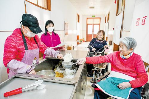 3月1日，在唐山市截瘫疗养院，工作人员给疗养员盛饭。本报记者 赵 杰摄