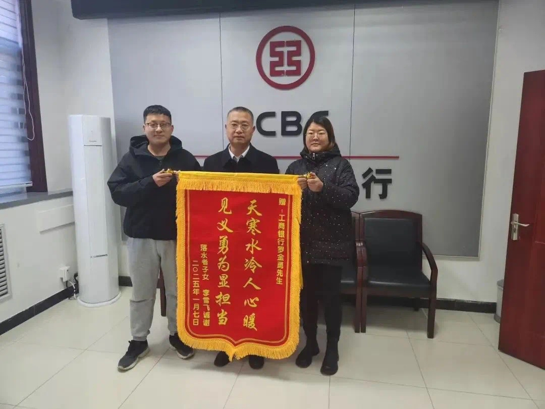 落水老人的家属向工行沧州泊头支行罗金勇送上写有“天寒水冷人心暖 见义勇为显担当”的锦旗表达感谢。宫轩供图