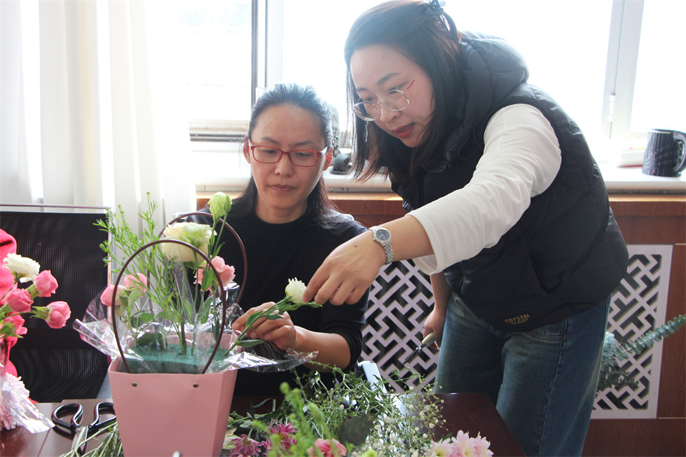 花艺师指导女职工学插花。杨瀰摄