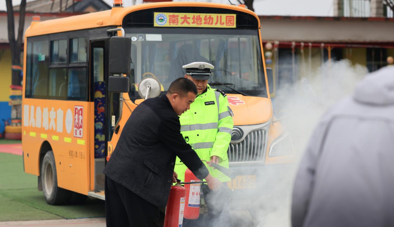 演练现场，易县公安交警大队民警与校车驾驶员在处置明火。杨增红摄