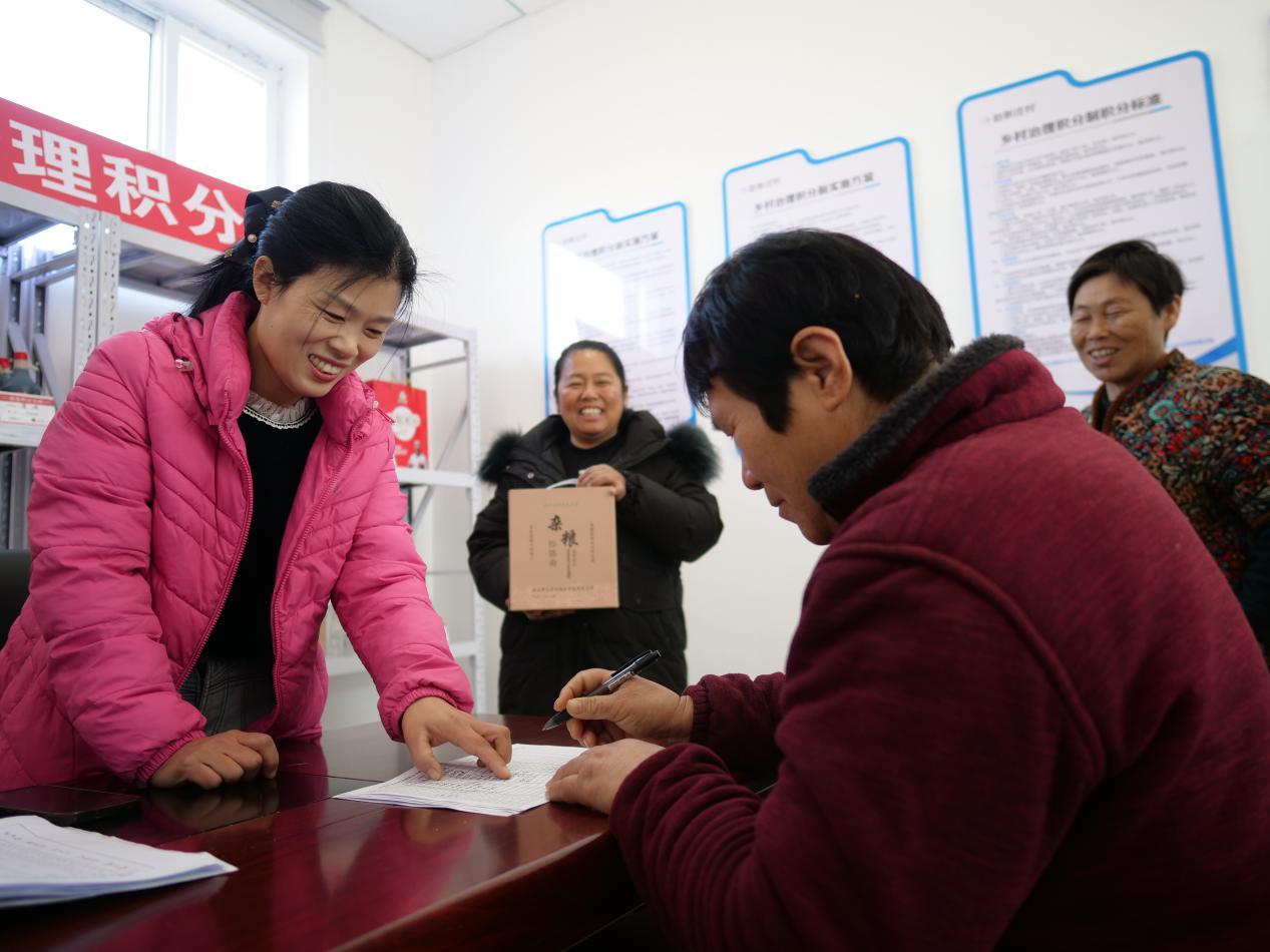 唐山市丰南区南孙庄镇赵新庄村村民在积分兑换表上签字。崔光摄
