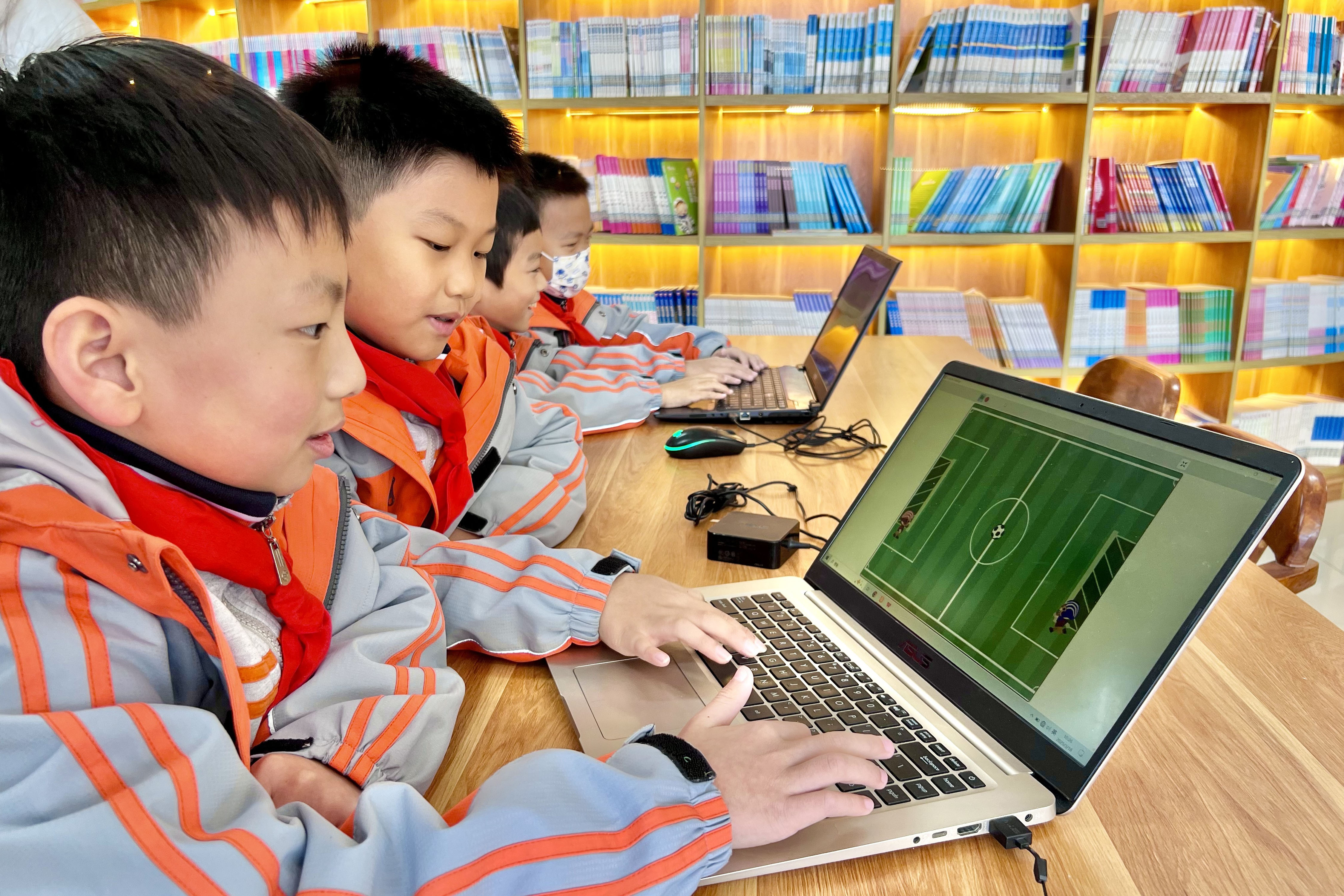 学生们体验用电脑编程设计的足球游戏。吴冰姿摄