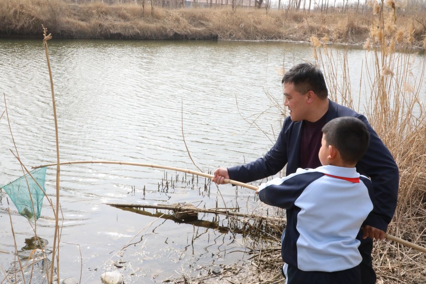 3月19日，师生在南排河清理水面垃圾。刘金忠摄
