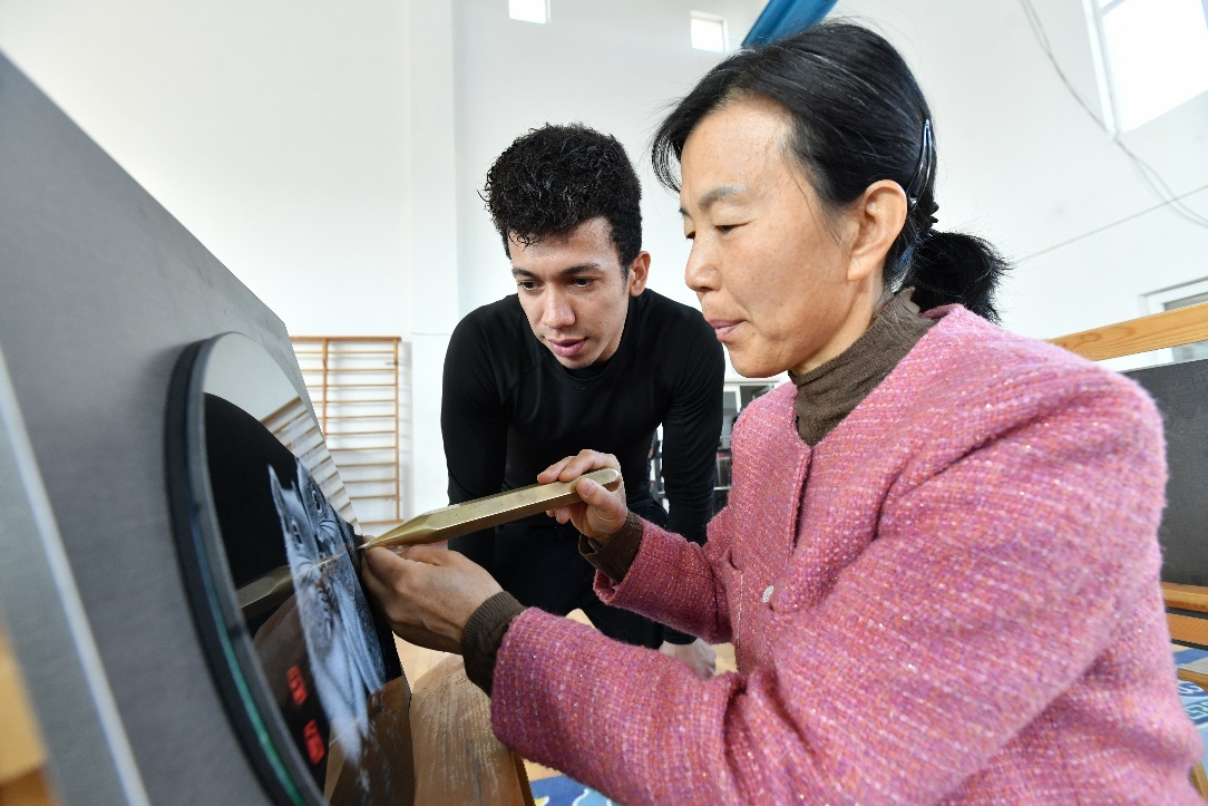 3月21日，在河北吴桥杂技艺术学校的排练厅里，乔恩·弗雷迪·马丁内斯在石影雕艺人的指导下学习石影雕技艺。苑立伟摄