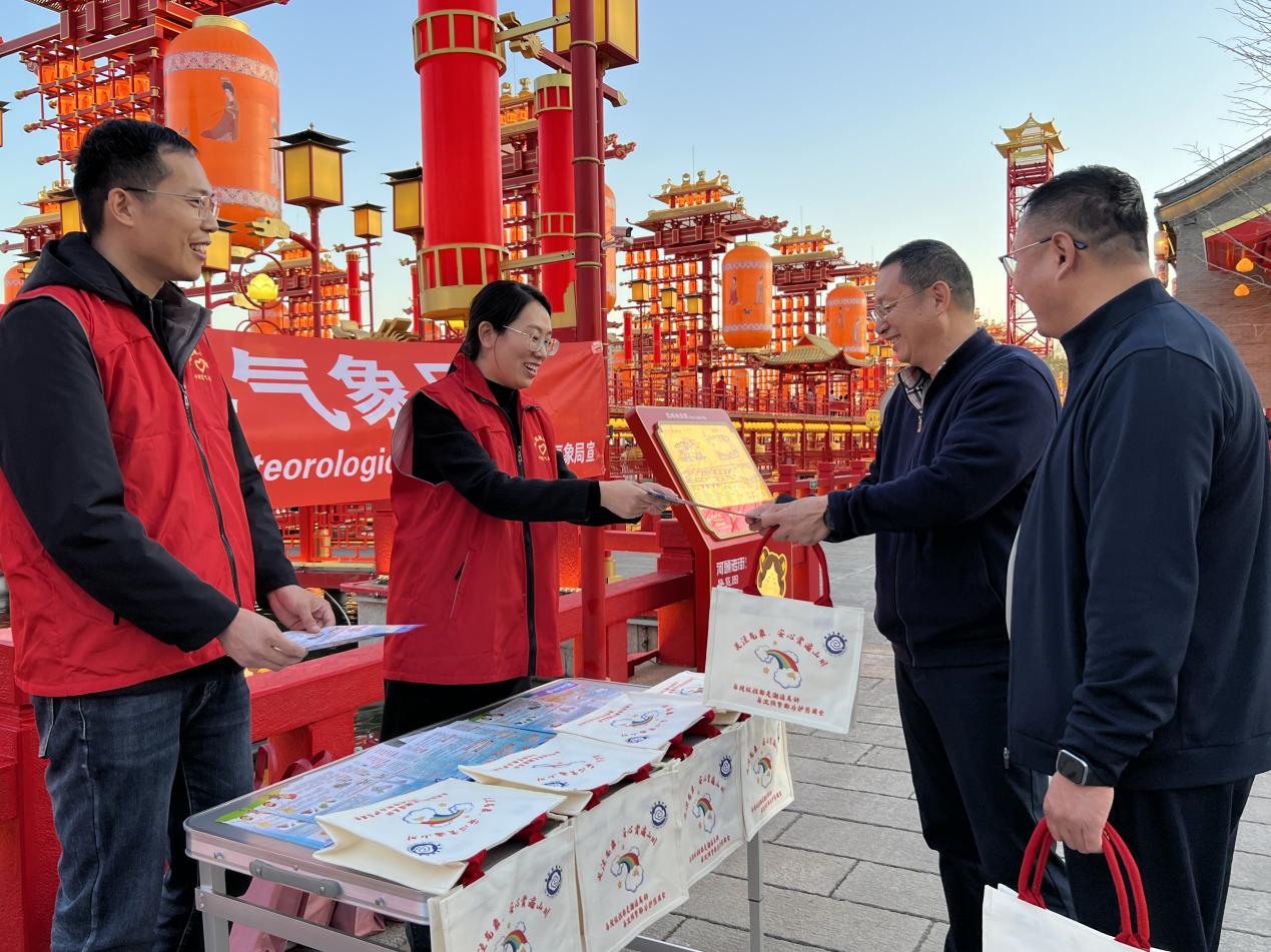 工作人员为游客发放气象宣传彩页和科普手提袋。刘洋摄