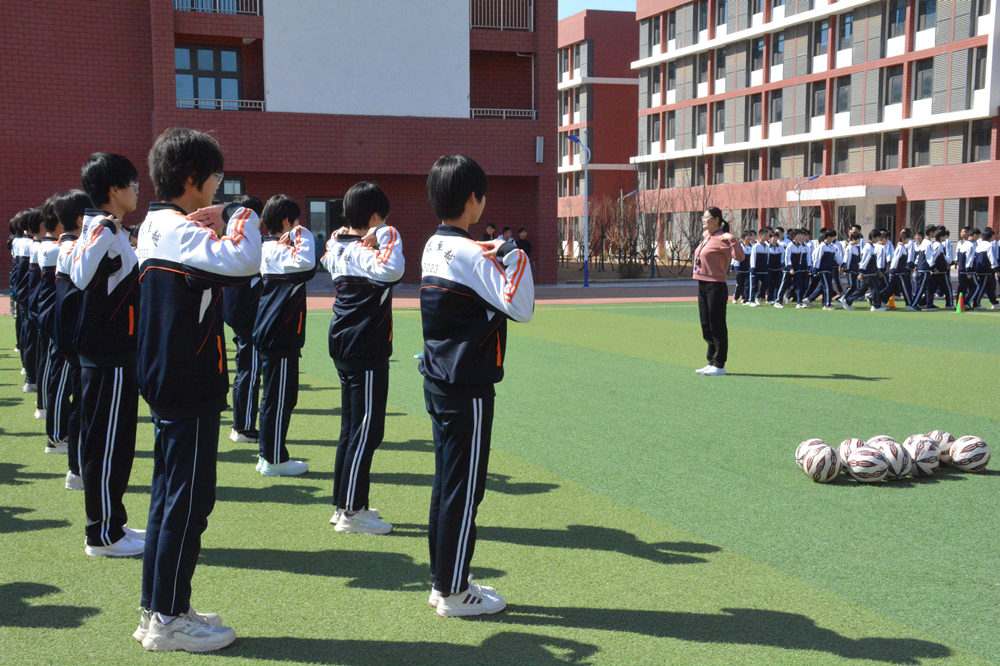 体育老师正在带领学生们进行热身活动。胡宇婷摄