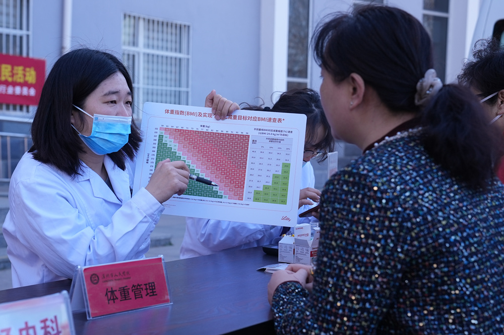 在义诊现场,医务人员为居民讲解体重管理知识。刘友辉摄