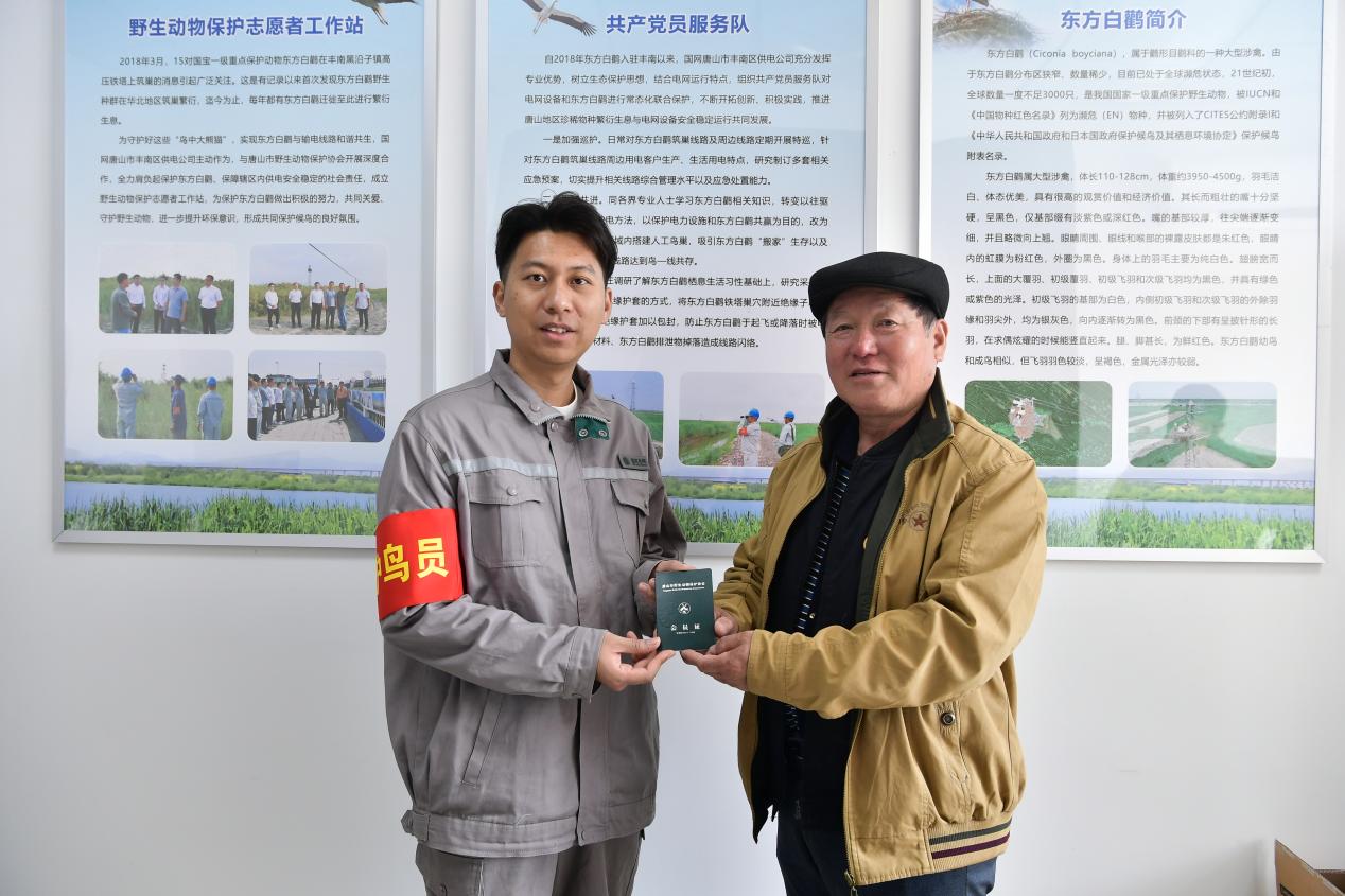 野保协会为电力员工颁发会员证。刘浩学摄