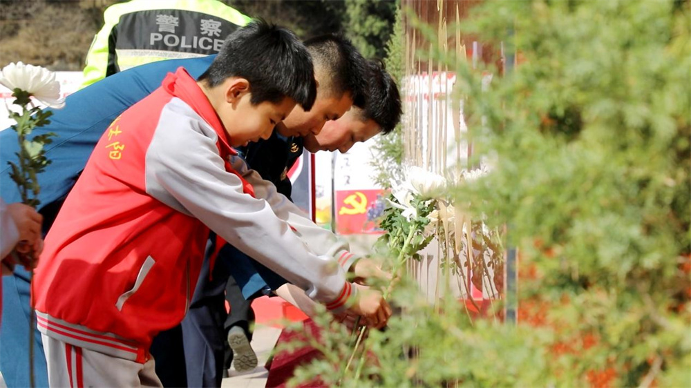 4月3日，全體人員依次向五勇士雕像鞠躬獻花。郭恩橋攝