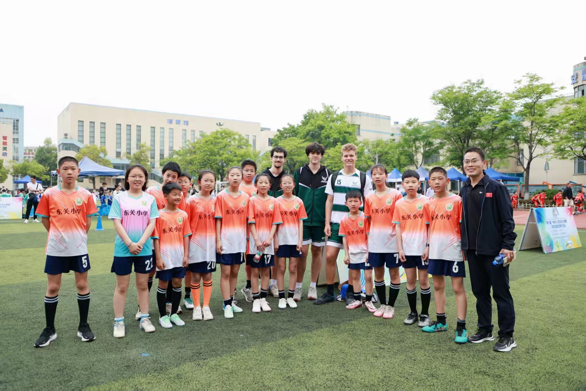 东关小学师生与外国高中足球队员合影。活动组委会供图