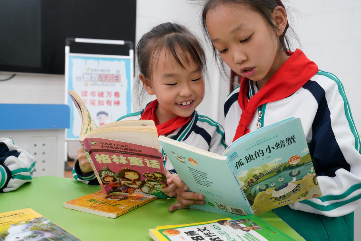 4月21日，河北沧州渤海新区黄骅市开发区小学学生在图书漂流活动中阅读书籍。褚金国摄