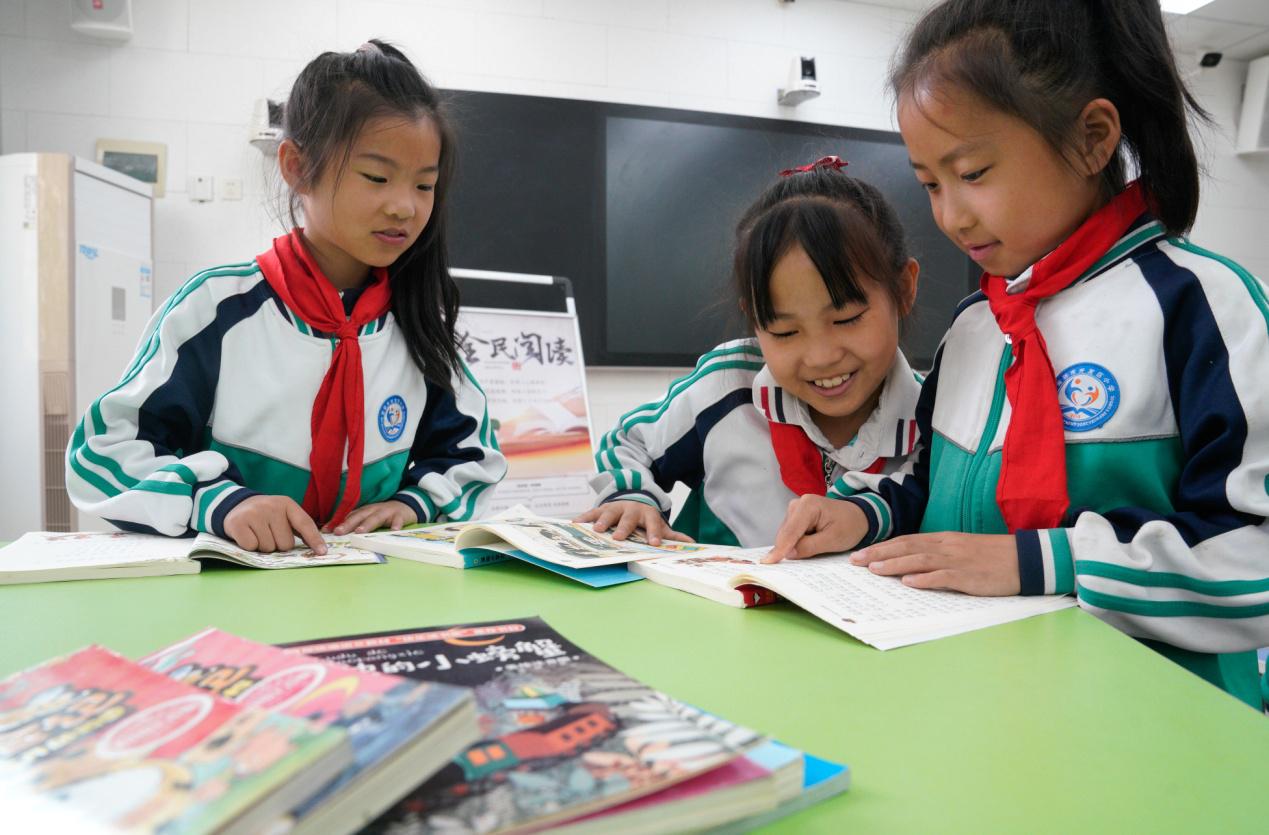 4月21日，河北沧州渤海新区黄骅市开发区小学学生在图书漂流活动中阅读书籍。褚金国摄