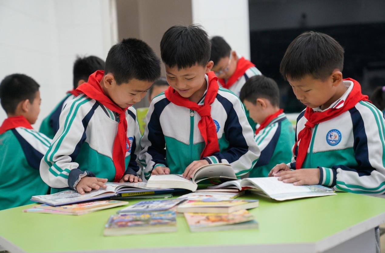 4月21日，河北沧州渤海新区黄骅市开发区小学学生在图书漂流活动中阅读书籍。褚金国摄