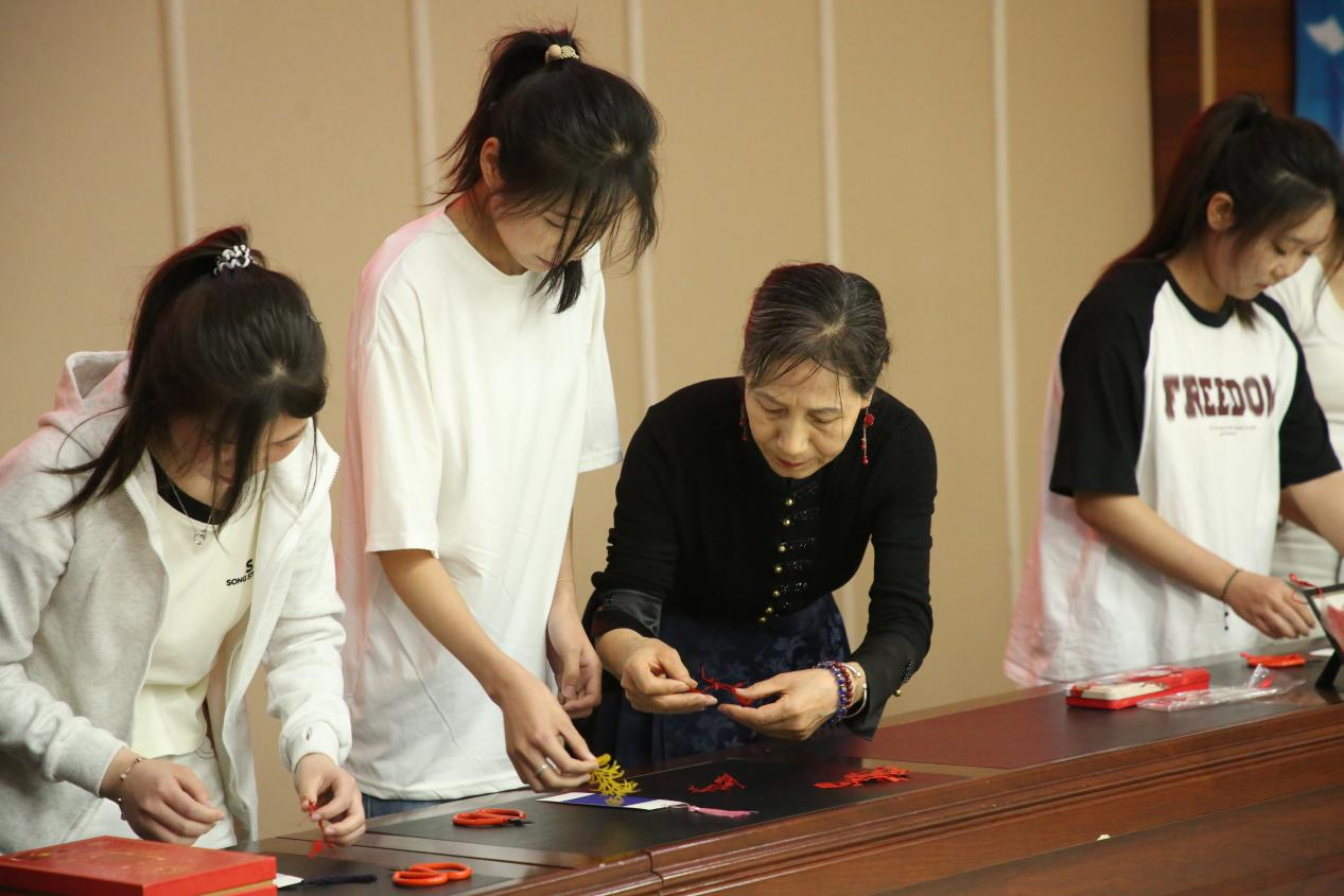 剪纸志愿服务队与大学生一起制作书签。时华清摄