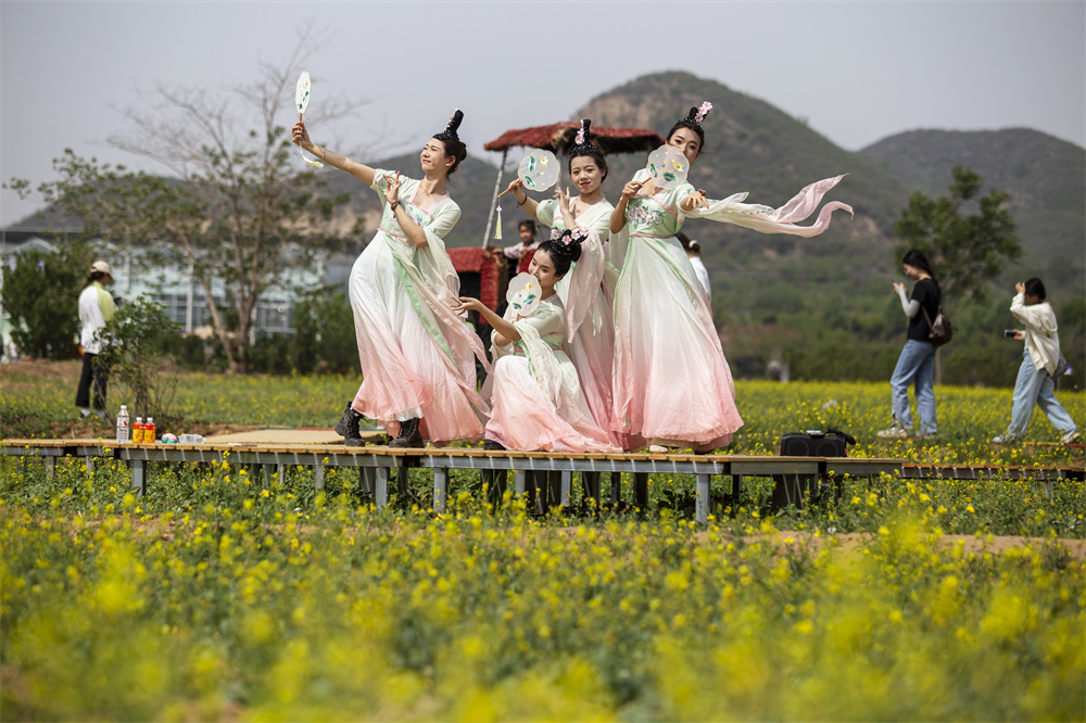 4月26日，河北省邯郸市复兴区二六七二街道东高河村油菜花海，演员为游客表演节目。聂长青摄