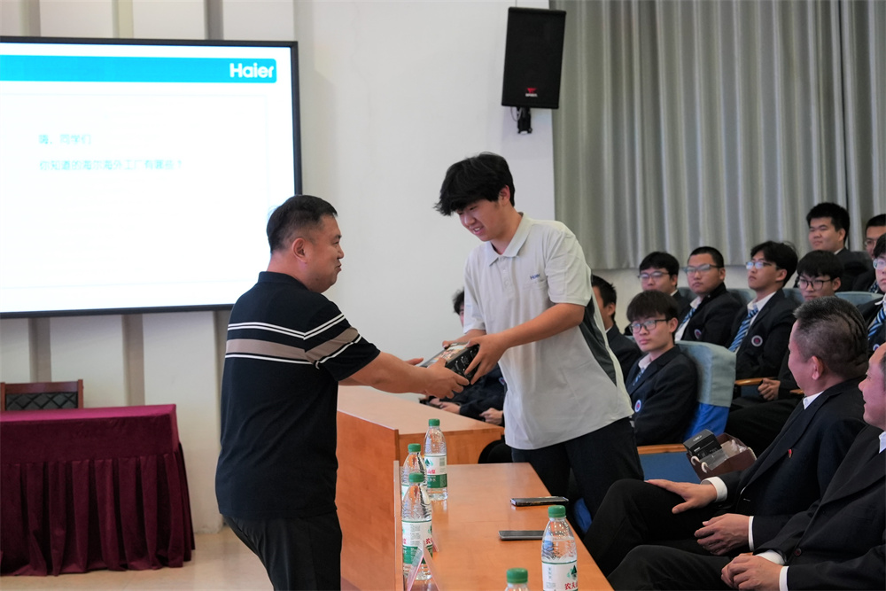 宣讲嘉宾刘海林向回答问题的学生马梓玄送上一份海尔公司专属定制的小礼品。董燮与摄