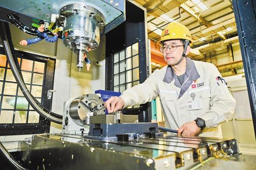 4月21日，張雪鬆在中車唐山公司復興號動車組鋁制車體產線上檢查數控加工中心。中車唐山公司供圖