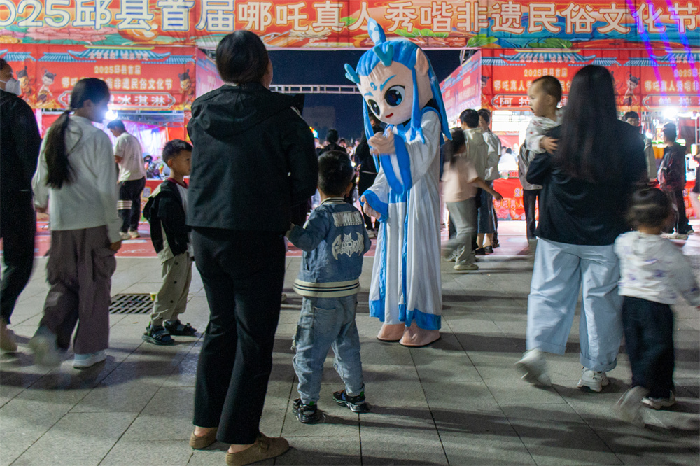 美食市集现场，“敖丙”吸引众多游客互动。陈贵平摄