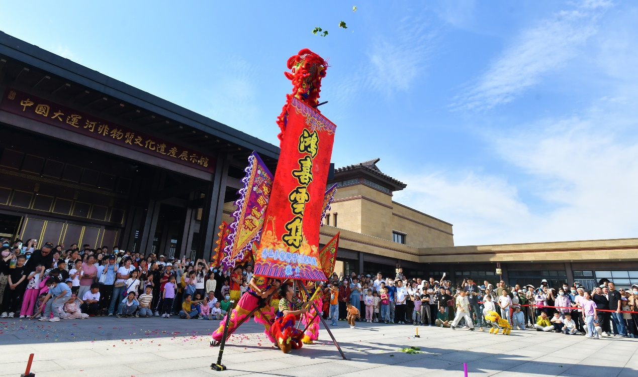 5月1日，在位于河北沧州的中国大运河非物质文化遗产展示馆广场，来自广东的舞狮团队为游客表演采青。苑立伟摄