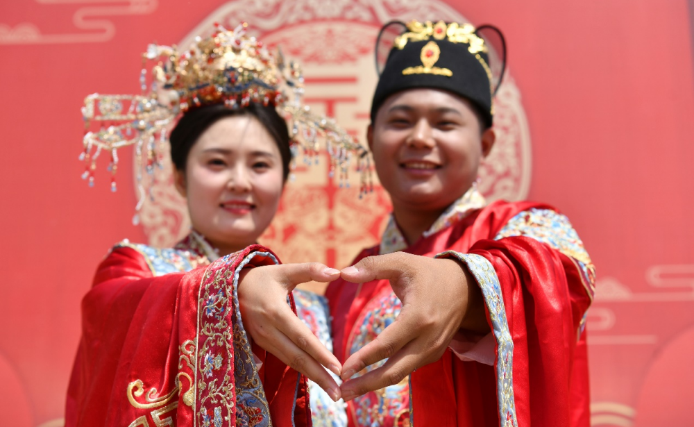 5月2日，一对新人在集体婚礼现场比心。苑立伟摄