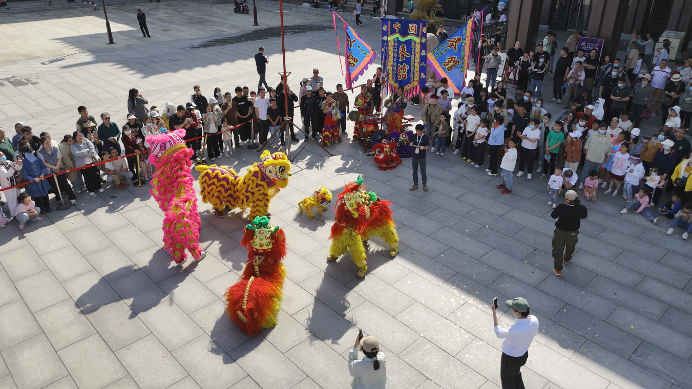 在中国大运河非物质文化遗产展示馆广场，南狮、北狮、机械狮同台演出，吸引游客围观。刘永圣摄