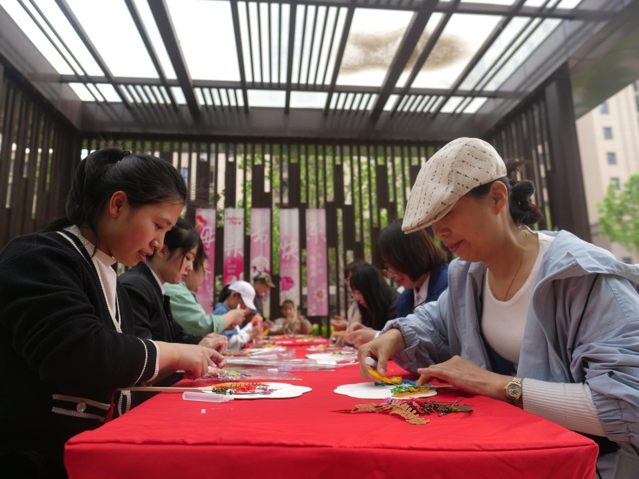 嘉誉瀞湖社区母亲节活动现场，居民制作花扇。崔光摄
