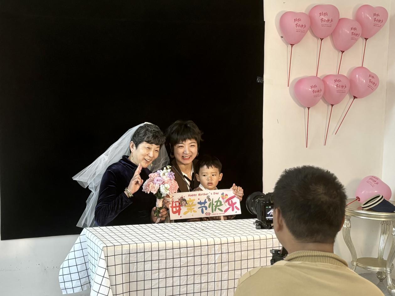 摄影师为嘉诚尚郡社区居民拍摄母亲节合影。付雪摄