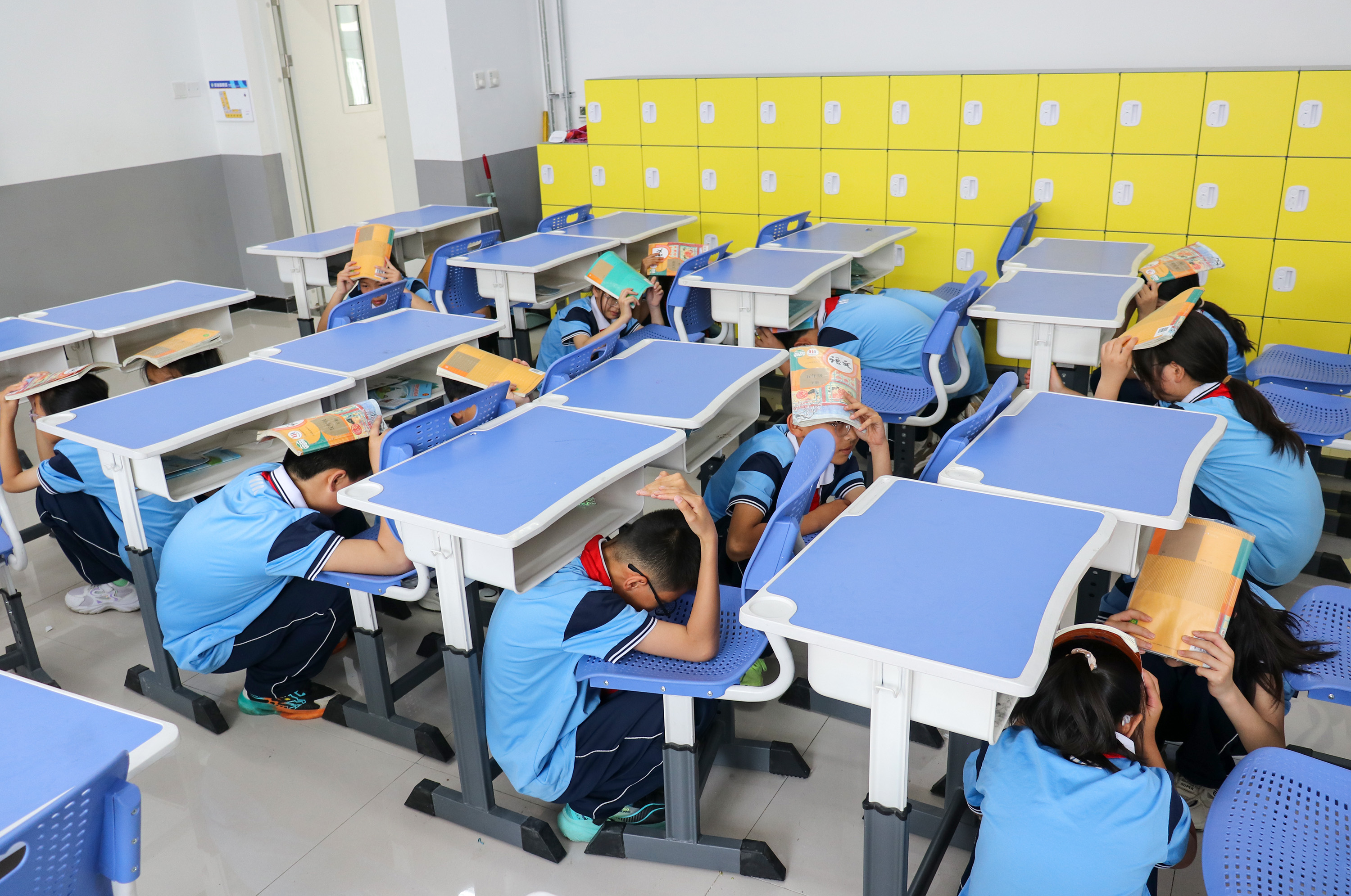 学生在教室内进行避震演练。耿培轩摄
