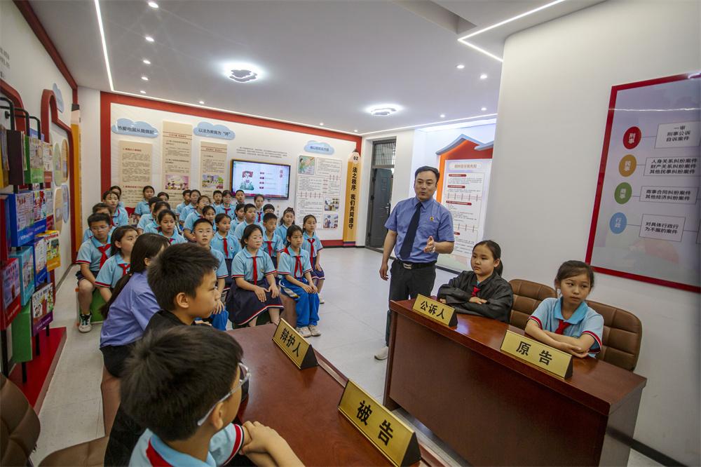 5月19日，河北省邯郸市复兴区岭南小学法治厅模拟法庭开庭，复兴区人民检察院检察官对模拟庭审进行专业点评。聂长青摄