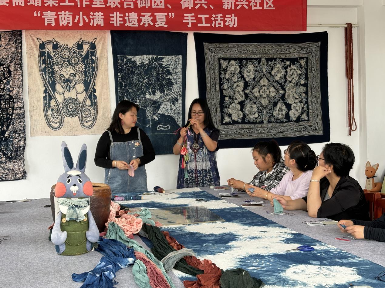 非遗蜡染艺人正在教居民们制作香囊。李萨摄