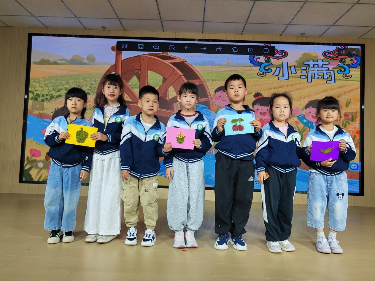 阅山幼儿园的孩子们展示制作好的五谷画。耿文娟摄