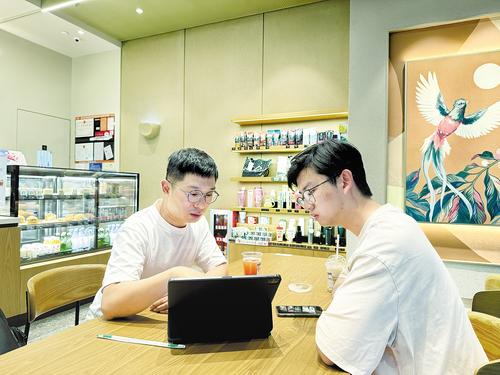 5月26日下午，怡享（河北）智能科技有限公司总经理张亮（左）在深圳考察完几家自动化设备制造企业后，抓紧与同事商讨订购计划。受访者供图