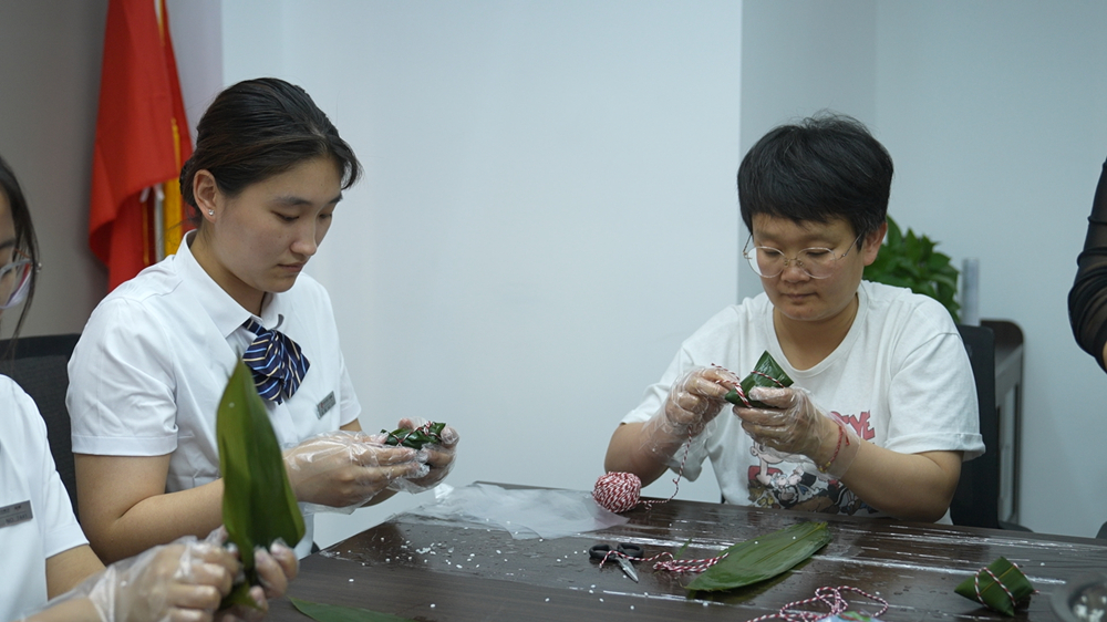沧州市新华区志强路社区联合辖区银行开展了包粽子活动。马鑫宇摄