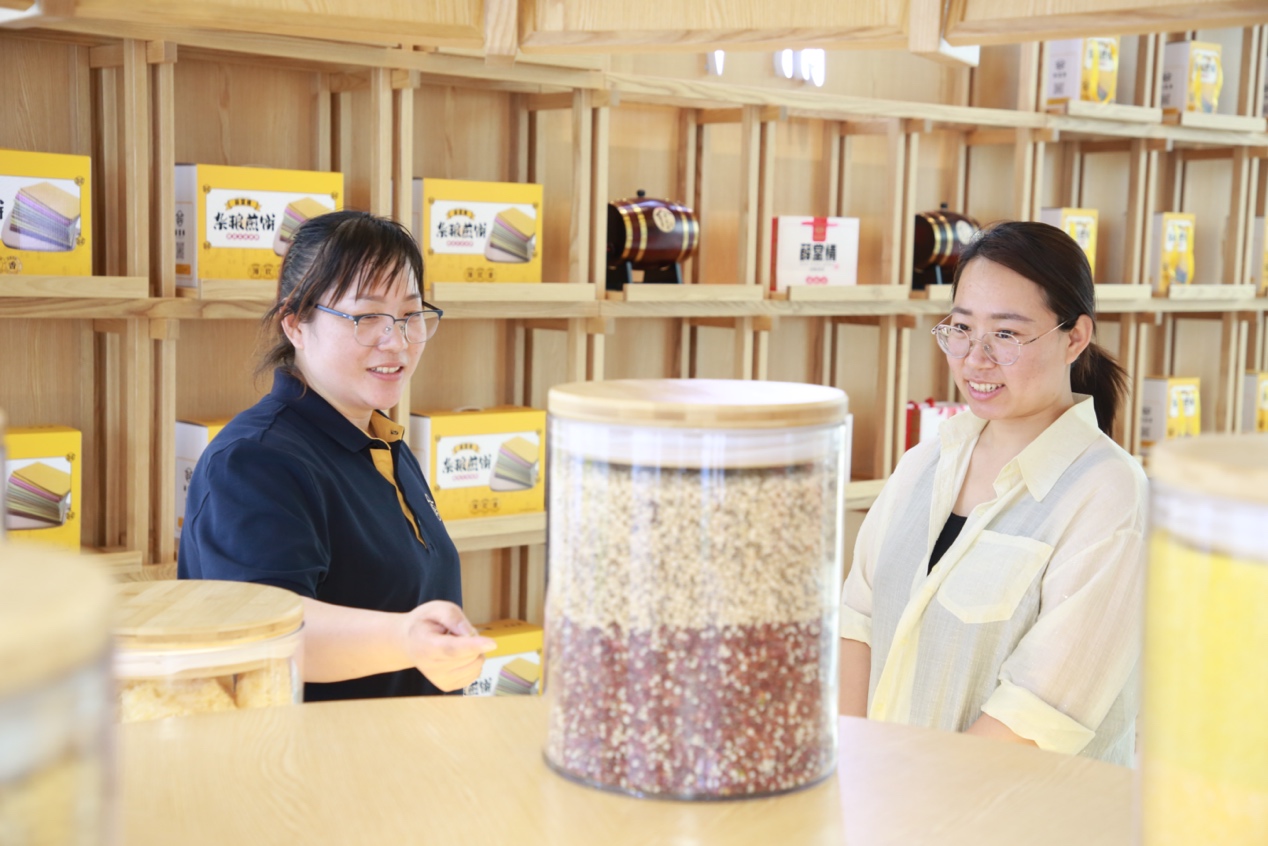 在河北省盐山县薛堂村一家煎饼加工厂的成品展示区内，一位工作人员正在向游客讲解煎饼制作工艺。殷实摄