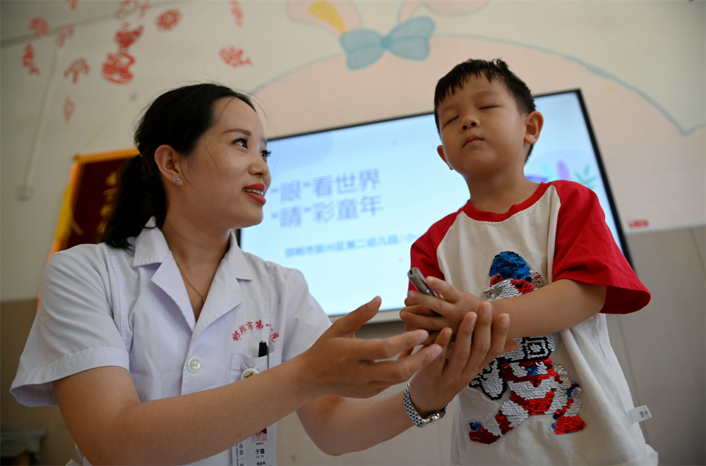 6月5日，河北省邯郸市复兴区第二幼园的小朋友在医务人员的指导下进行“闭眼摸物”游戏。周绍宗摄