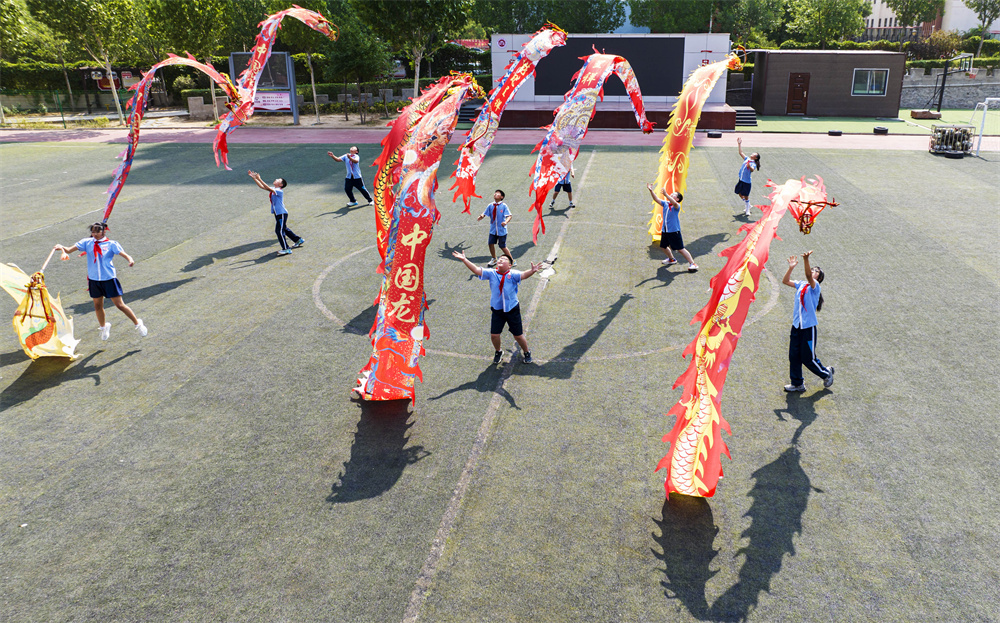 6月12日，河北省邯郸市复兴区实验小学操场，孩子们舞动彩龙上下翻飞。聂长青摄