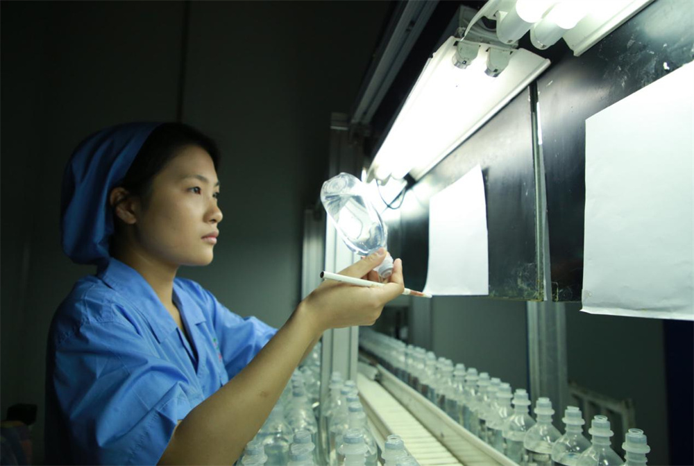 6月11日，在河北天成药业股份有限公司的灯检室内，工作人员检验产品质量。殷实摄