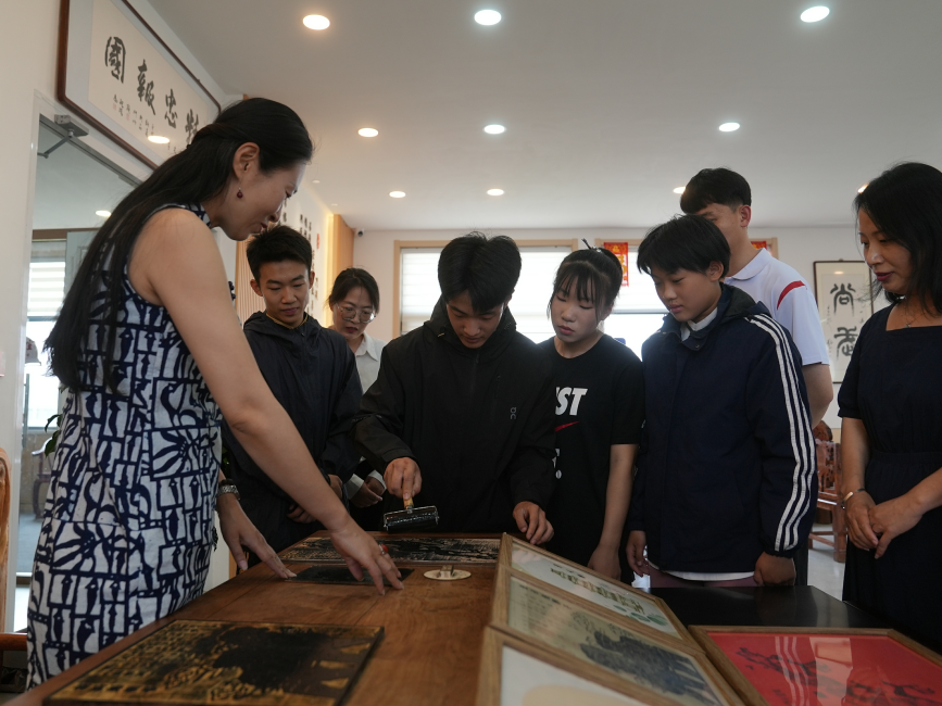 青少年在老师的指导下体验调版印刷术。刘友辉摄
