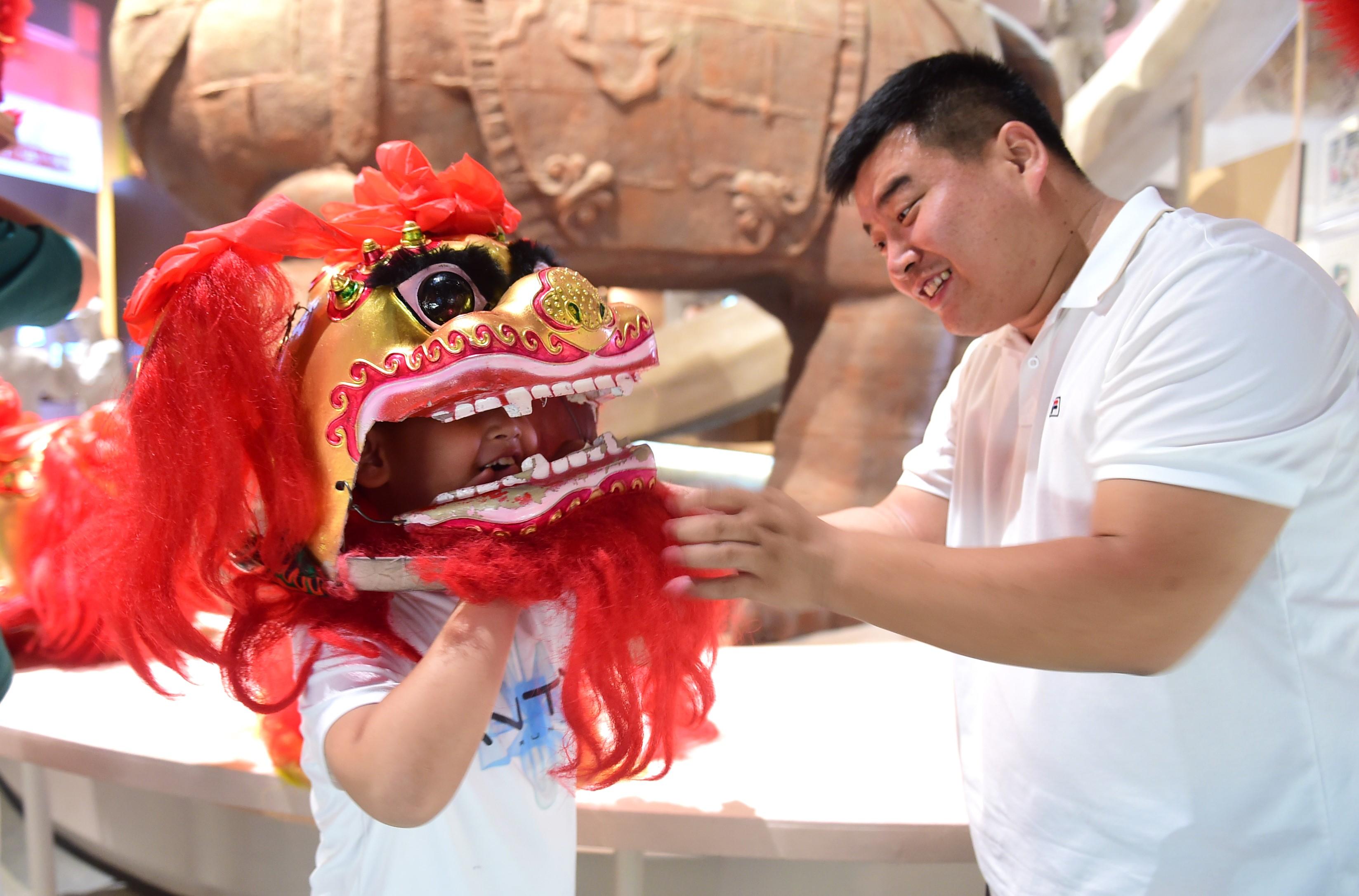 孩子在中国大运河非遗展示馆内体验舞狮表演。傅新春摄